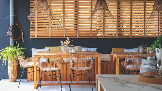 La cuisine d'été, avec ses ambiances vannerie et rotin pour la légèreté, bois et marbre pour le confort, donne sur le jardin et la piscine.